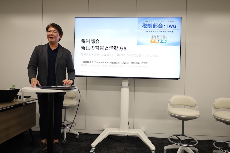 「税制部会 新設の背景と活動方針」と題したスライドで説明する様子